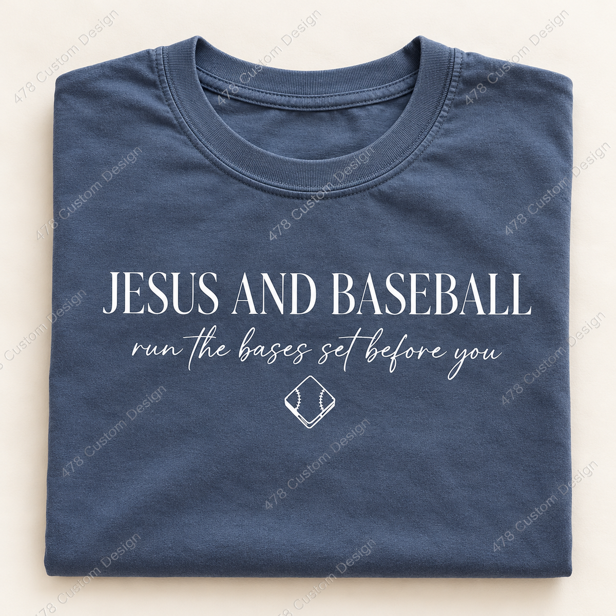Folded slate-blue shirt with white Jesus and Baseball run the bases set before you front print
