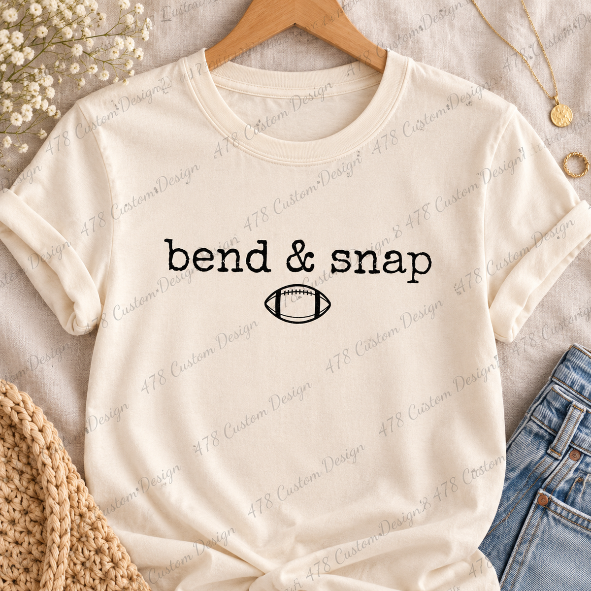 Bend and snap black football design on a cream tee