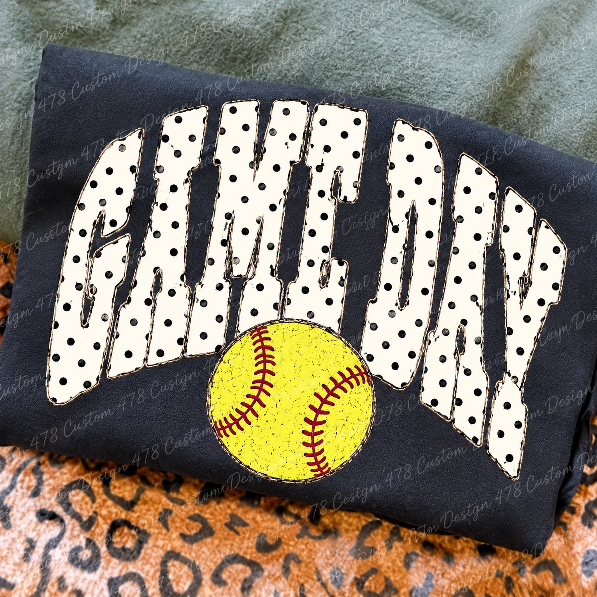 Polka Dot Game Day Softball design on a folded charcoal shirt