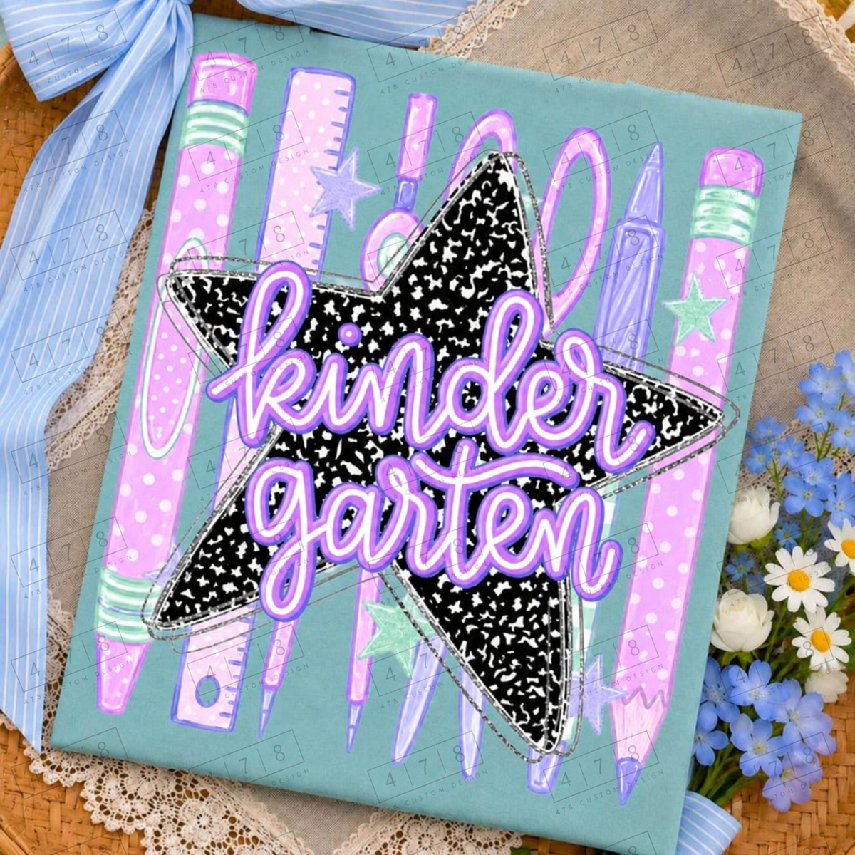 Kindergarten pastel school supplies notebook star design on a seafoam folded shirt