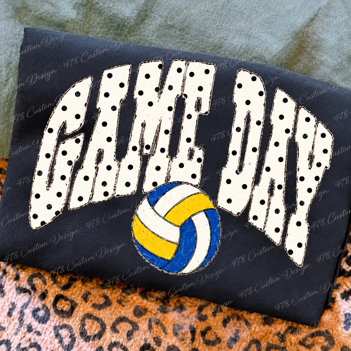 Polka Dot Game Day Volleyball design on a folded charcoal shirt